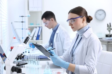 Photo of Scientists working with laboratory test form indoors. Medical research