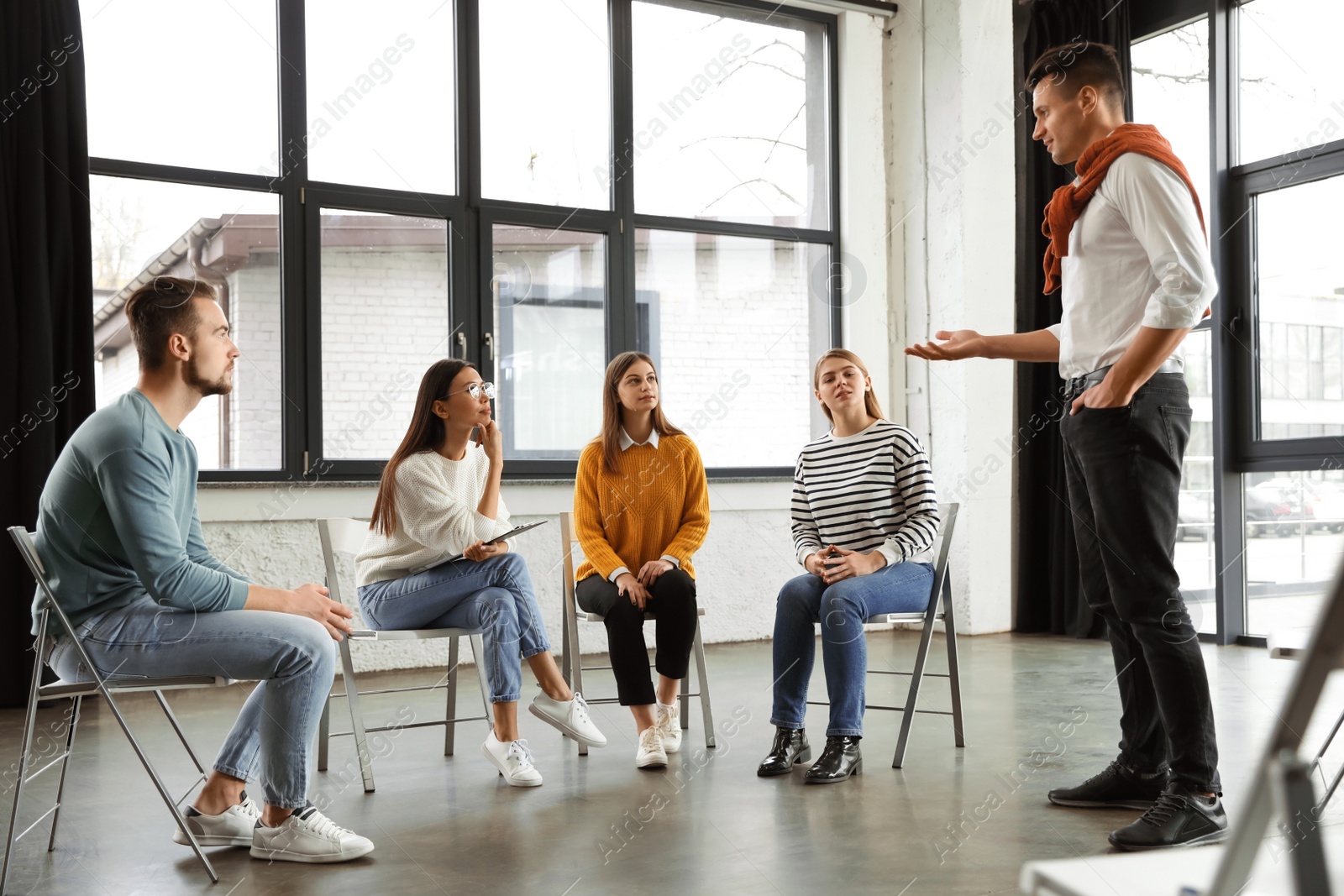 Photo of Psychotherapist working with patients in group therapy session indoors