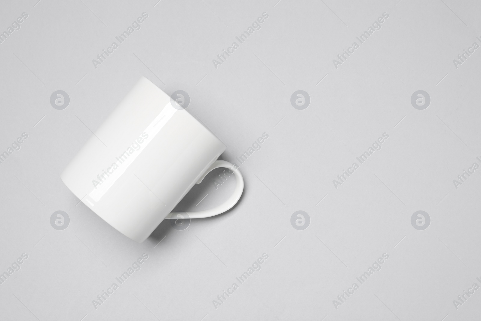 One white ceramic mug on light background, top view and space for text Photo of One white ceramic mug on light background, top view and space for text