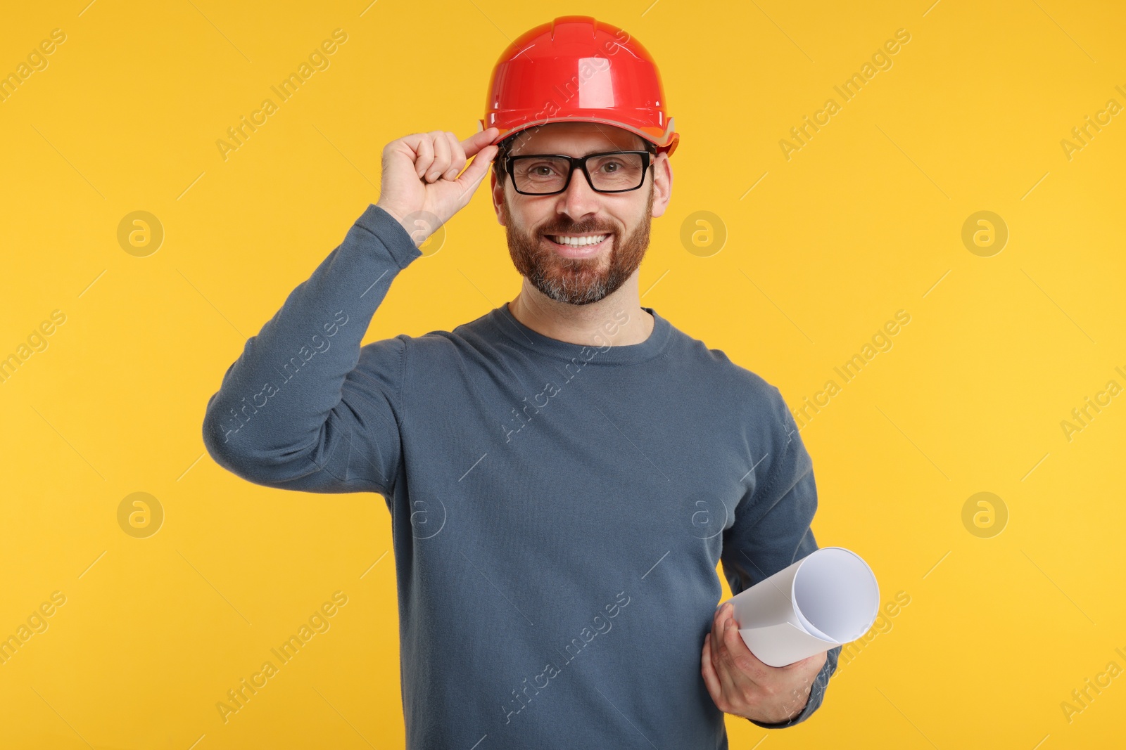 Photo of Architect in hard hat with draft on orange background