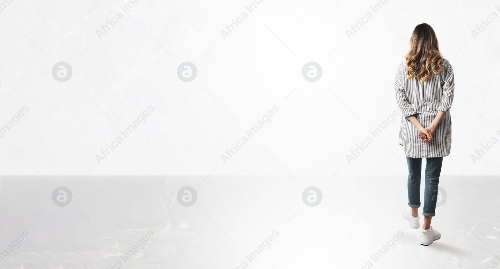 Image of Woman standing in front of light marble wall, back view. Banner design with space for text