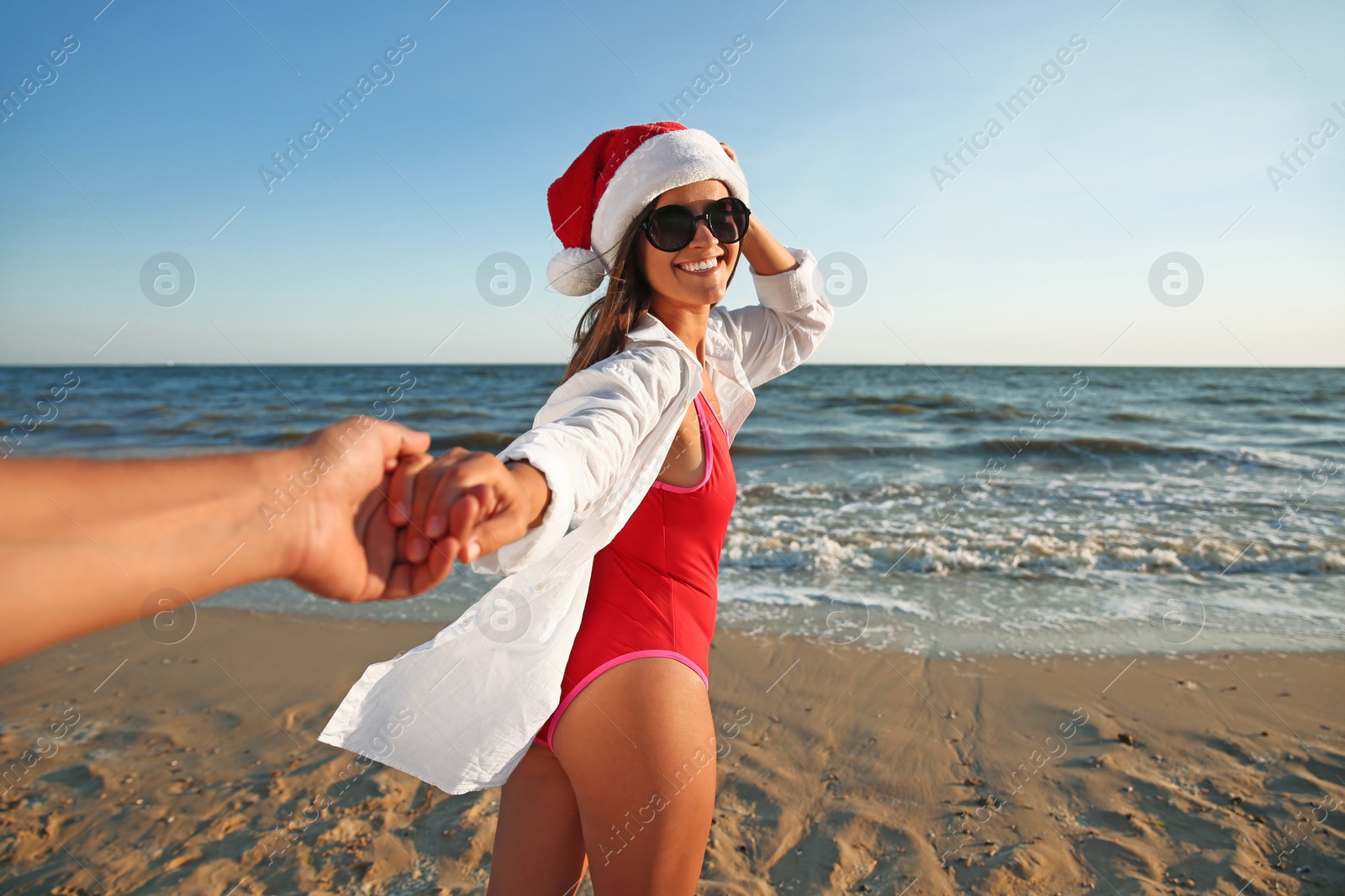 Photo of Lovely couple with Santa hat on beach. Christmas vacation