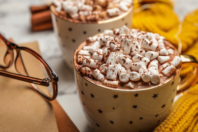 Cup of delicious hot cocoa with marshmallows on white table, closeup