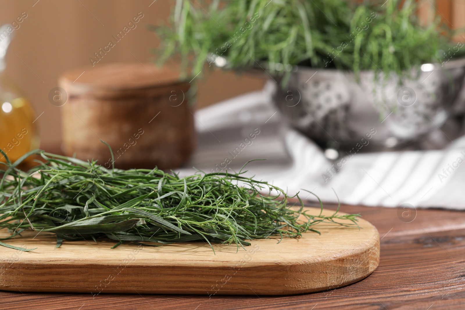 Photo of Board with fresh tarragon leaves on wooden table, closeup. Space for text