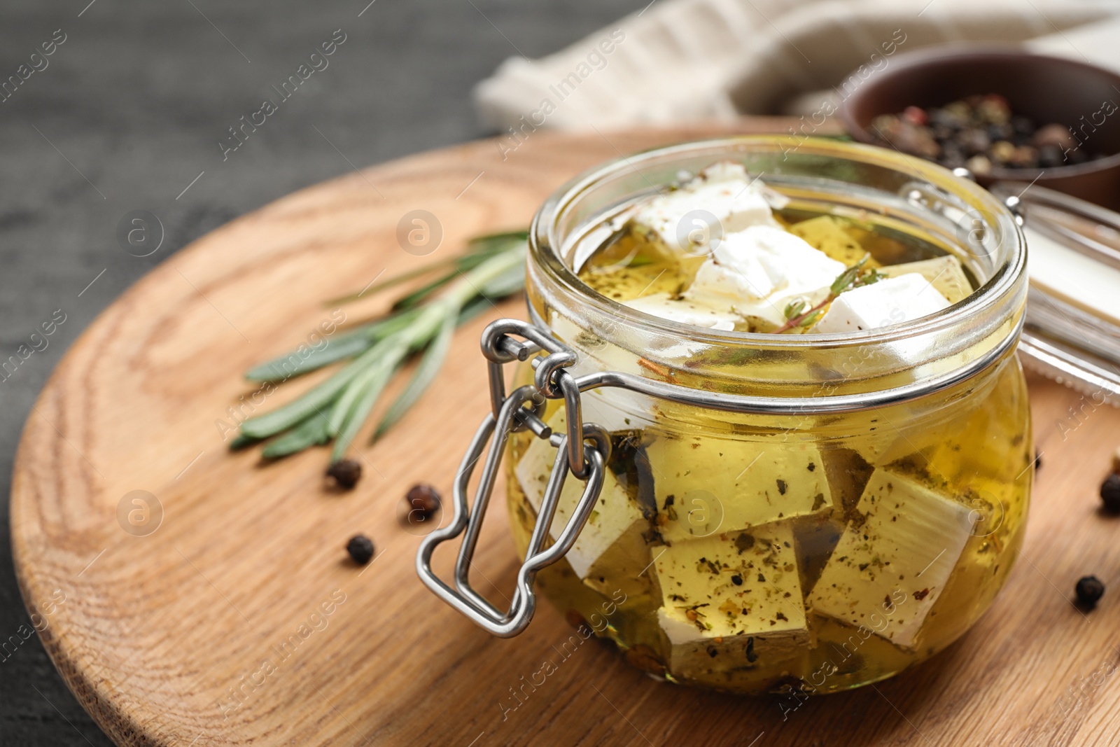 Photo of Jar with feta cheese marinated in oil on table. Pickled food