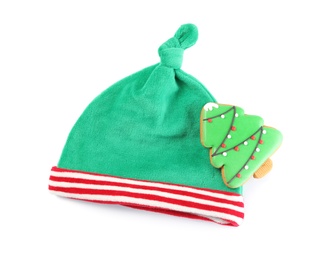 Photo of Cute small elf hat and gingerbread on white background, top view. Christmas baby clothes
