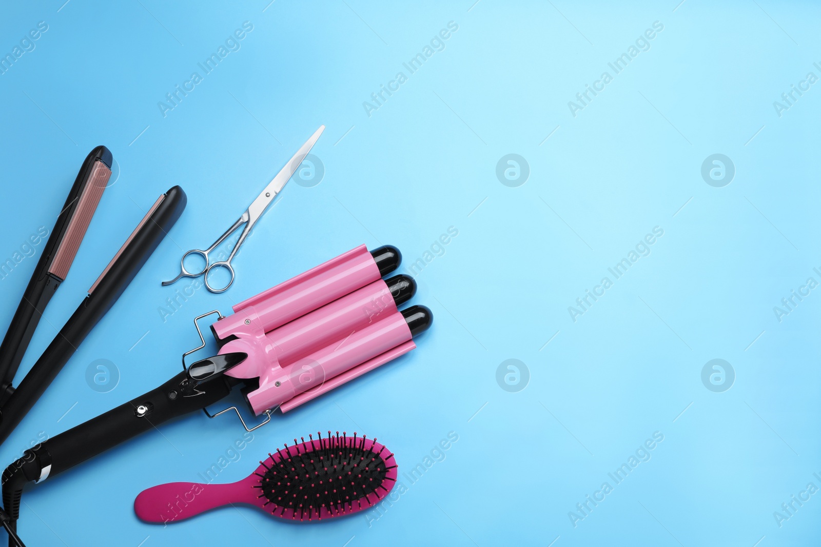 Photo of Flat lay composition of professional hairdresser tools on light blue background, space for text