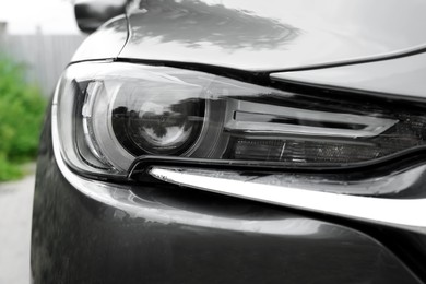Closeup view of clean car headlight outdoors