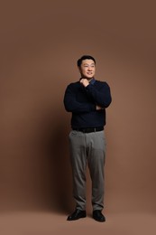 Full length portrait of happy man on brown background