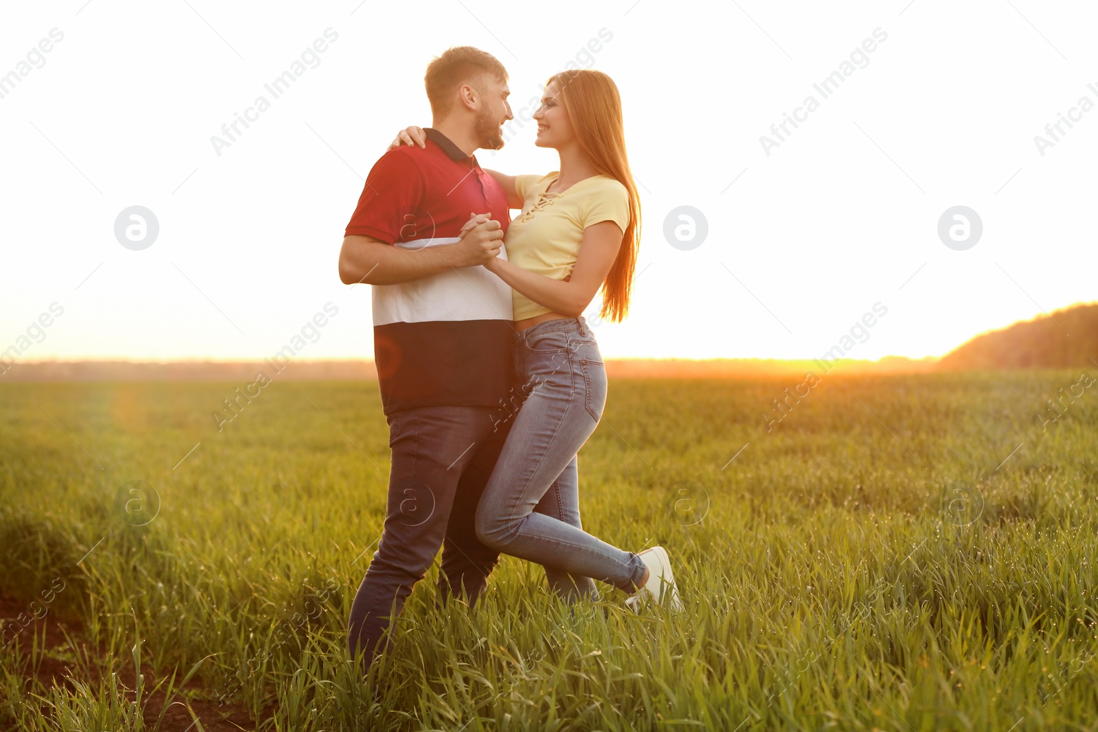 Photo of Happy young couple in green field on sunny spring day