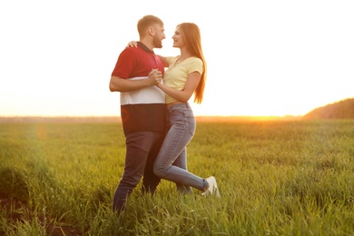 Happy young couple in green field on sunny spring day