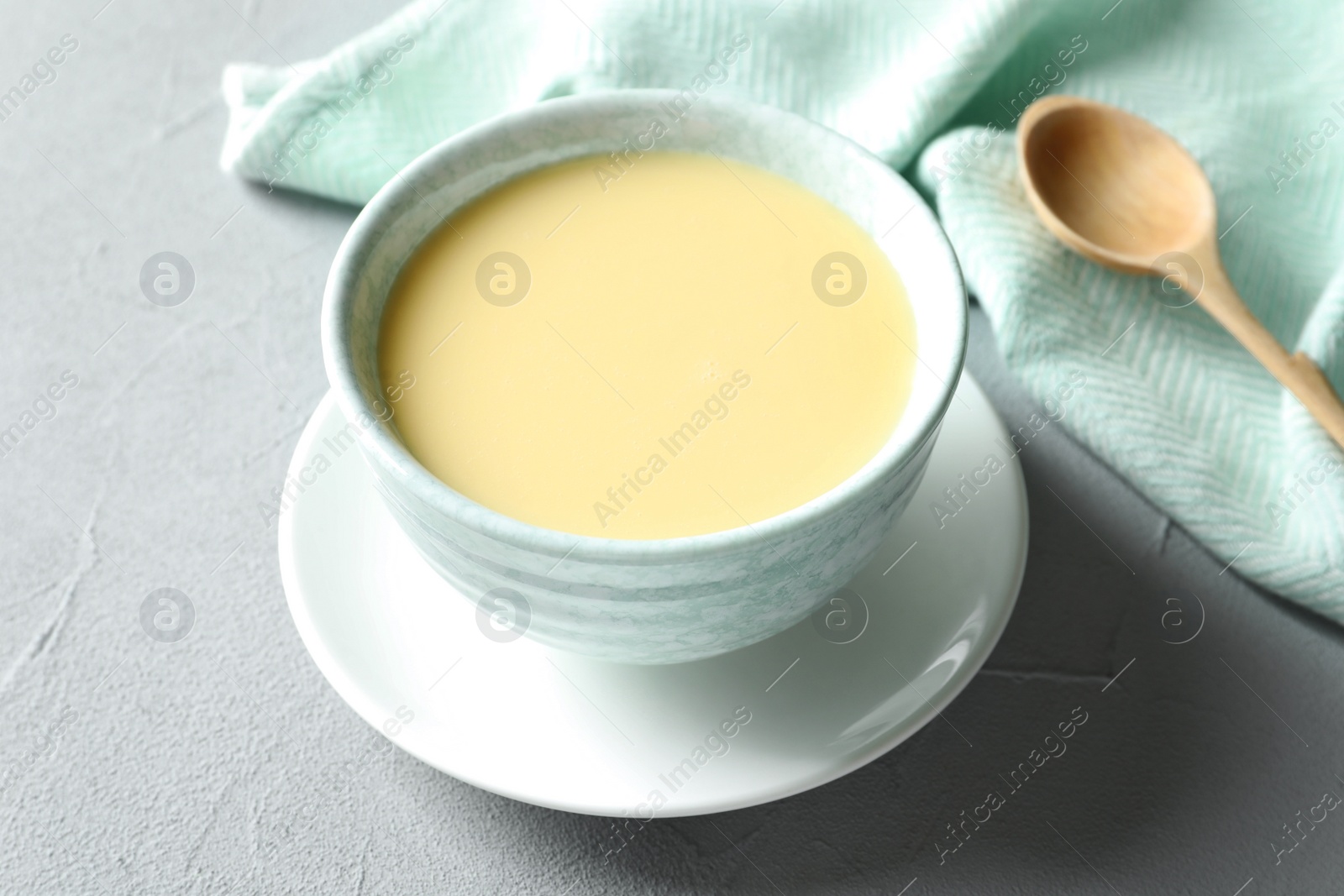 Photo of Bowl with condensed milk served on table. Dairy products