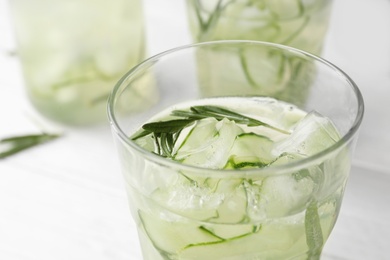 Photo of Glass of refreshing cucumber lemonade on table, closeup. Summer drink