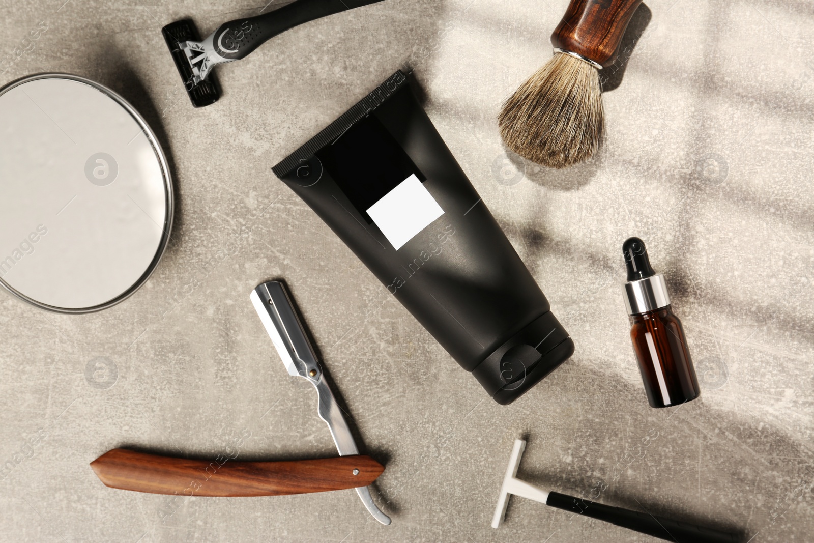 Photo of Set of men's shaving tools on light gray textured table, flat lay