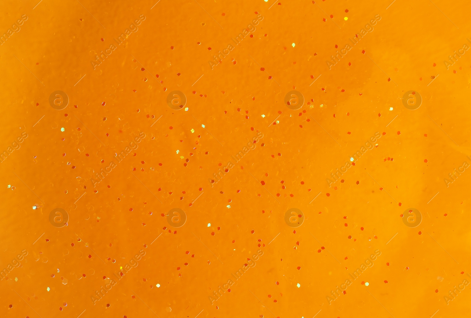 Photo of Orange slime with glitter, closeup. Antistress toy