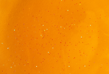 Photo of Orange slime with glitter, closeup. Antistress toy