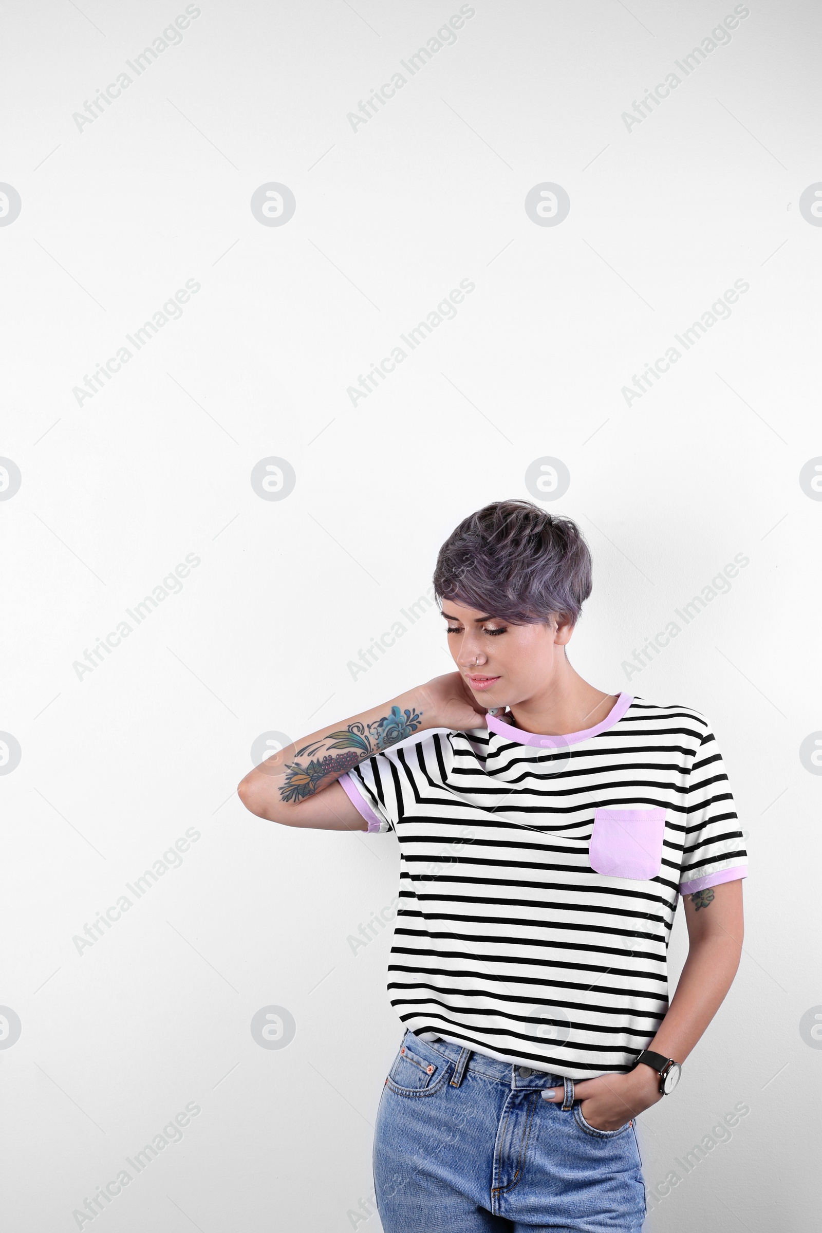 Photo of Trendy young woman with tattoos on white background. Space for text