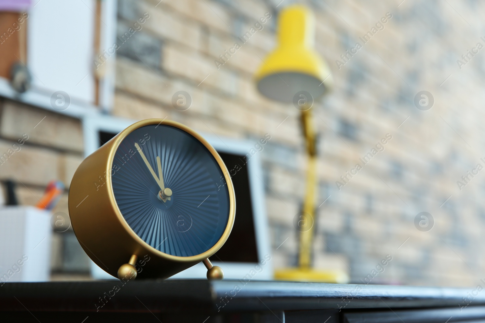 Photo of Alarm clock near laptop on table indoors. Time management