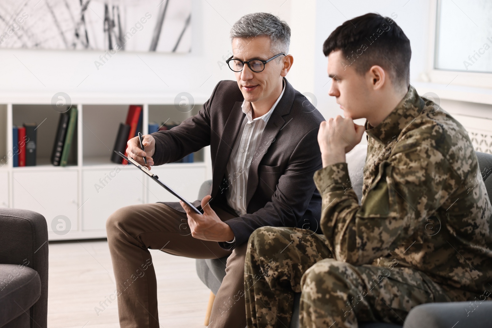 Photo of Professional psychotherapist working with military man in office