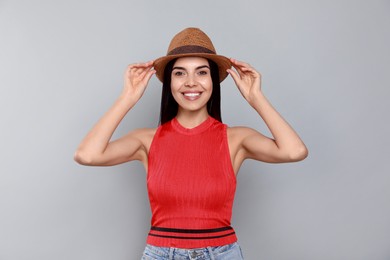 Photo of Beautiful young woman with straw hat on light grey background