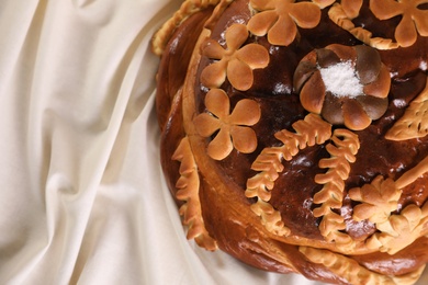 Photo of Korovai on tablecloth, top view. Ukrainian bread and salt welcoming tradition