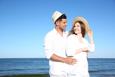 Lovely couple wearing hats together on beach