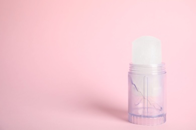 Photo of Natural crystal alum stick deodorant on pink background. Space for text