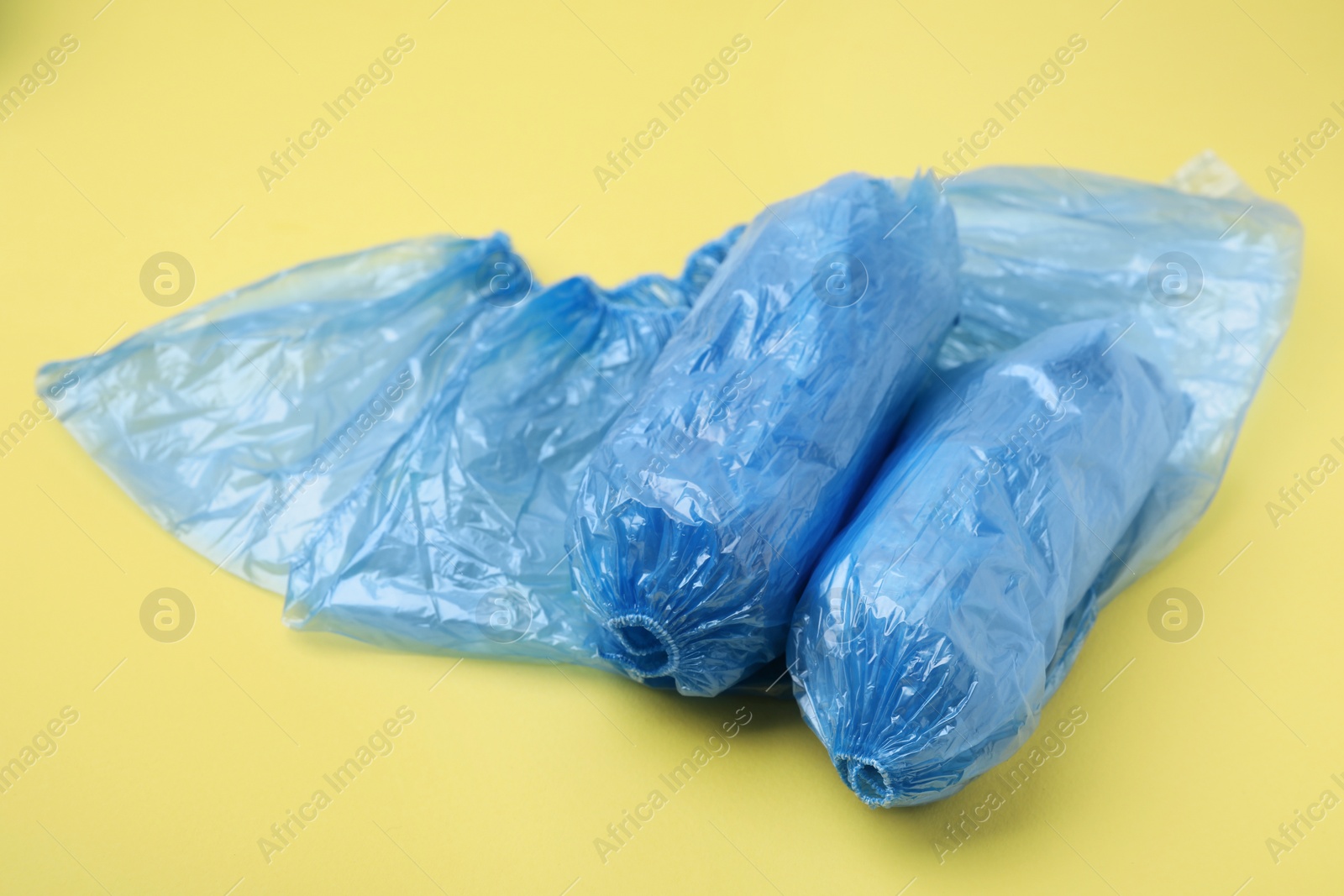 Photo of Blue medical shoe covers on yellow background