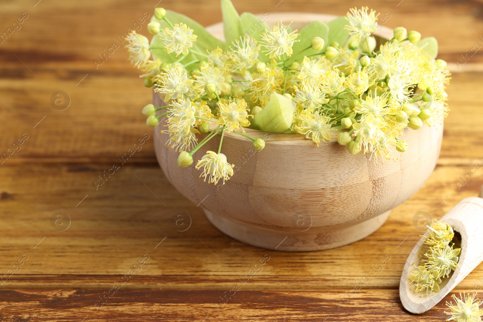 Photo of Fresh linden leaves and flowers on wooden table