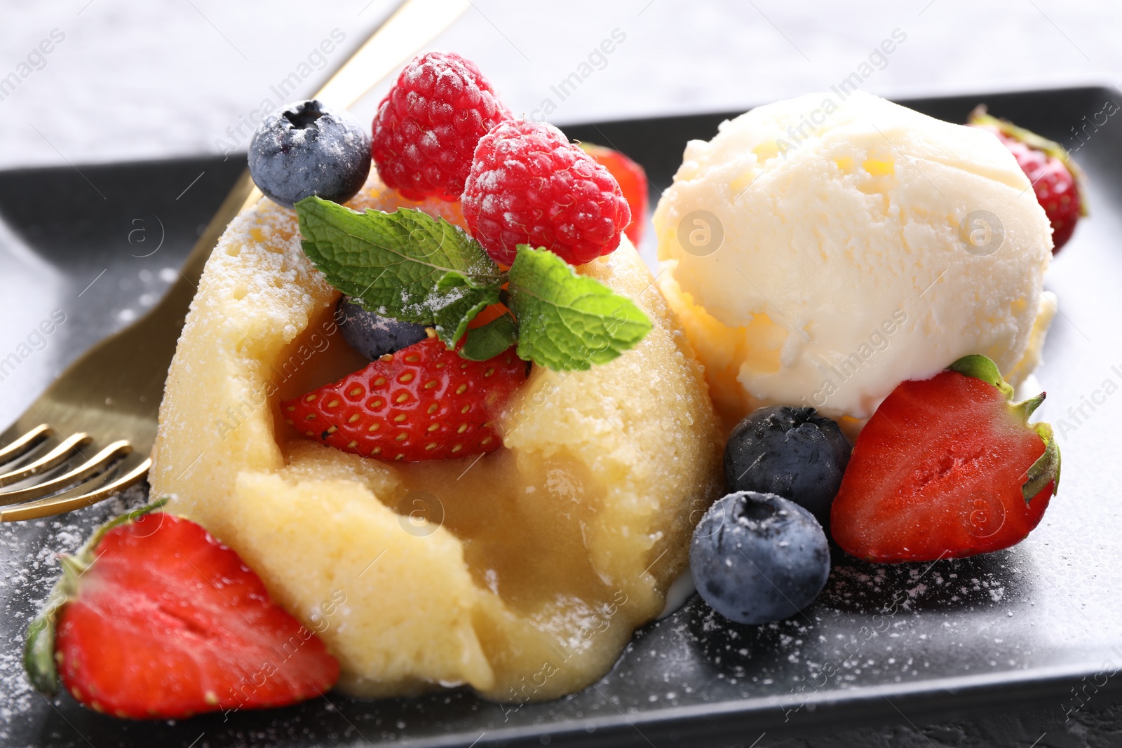 Photo of Tasty vanilla fondant with white chocolate, berries and ice cream on table, closeup