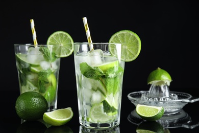 Photo of Delicious mojito and ingredients on black background