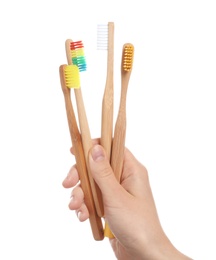 Photo of Woman holding wooden toothbrushes on white background