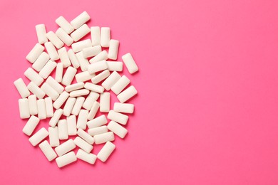 Photo of Many chewing gum pieces on pink background, flat lay. Space for text
