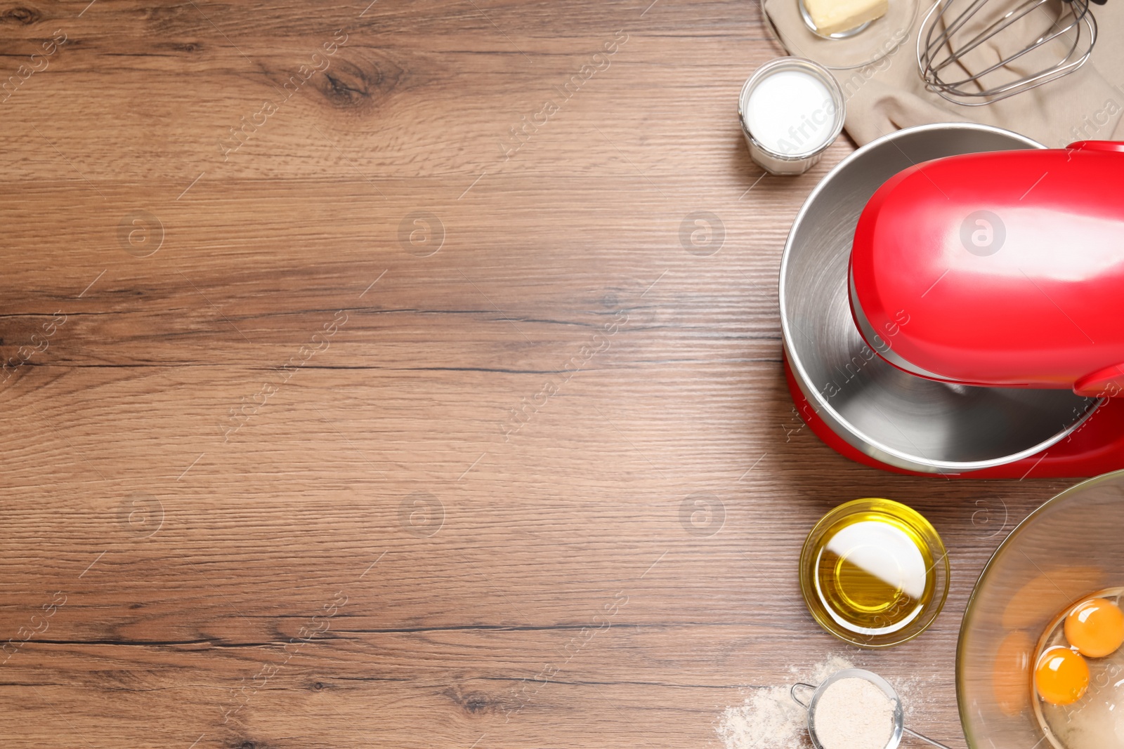 Photo of Red stand mixer and different ingredients on wooden table, flat lay. Space for text