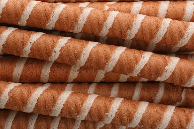 Tasty wafer roll sticks as background, top view. Crispy food