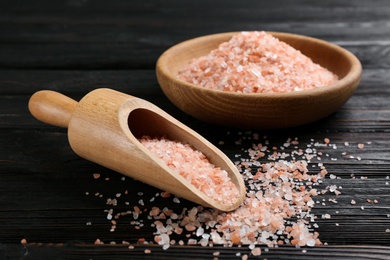 Pink himalayan salt in scoop and bowl on wooden table