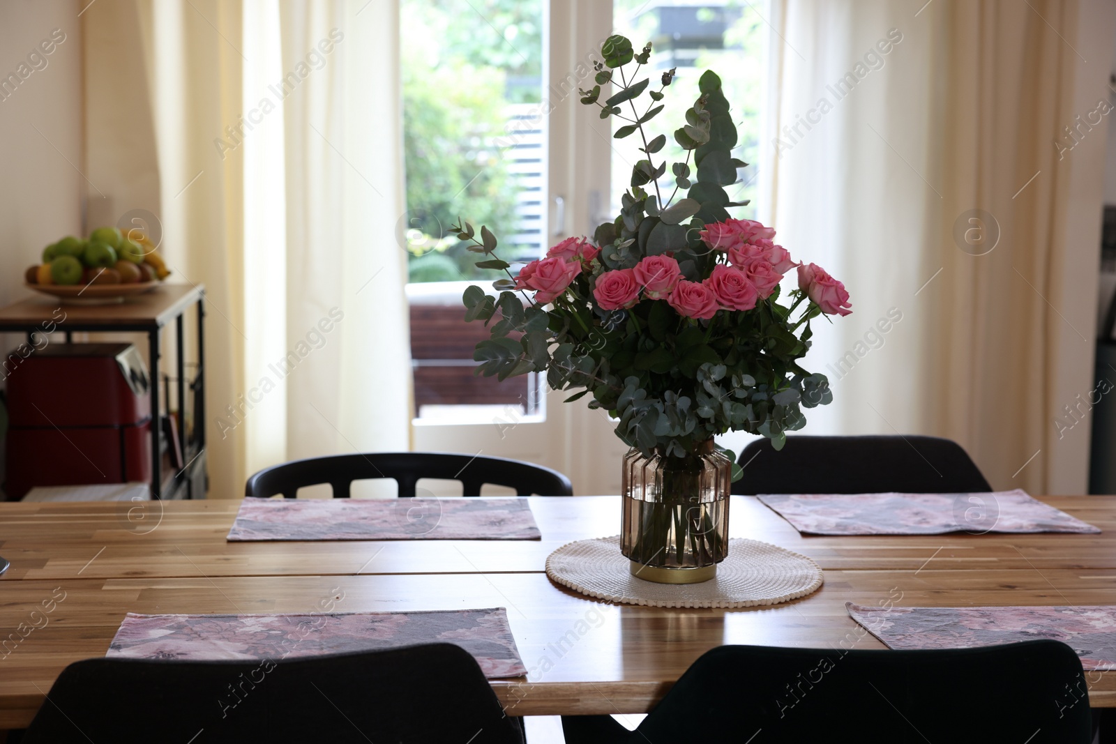 Photo of Beautiful bouquet of roses and napkins on wooden table indoors