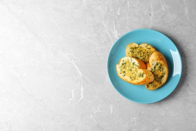 Photo of Slices of toasted bread with garlic, cheese and herbs on grey table, top view. Space for text