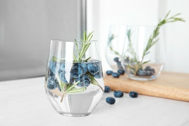 Photo of Refreshing blueberry cocktail with rosemary on table