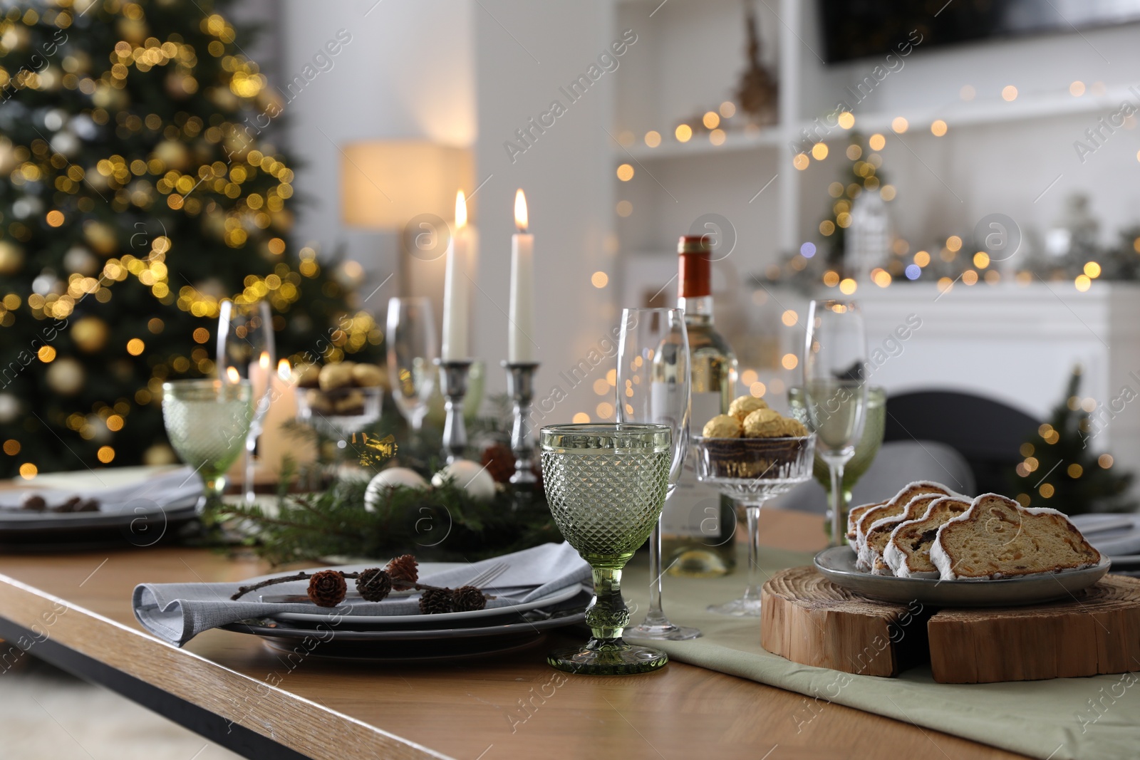 Photo of Christmas table setting with festive decor and dishware in room