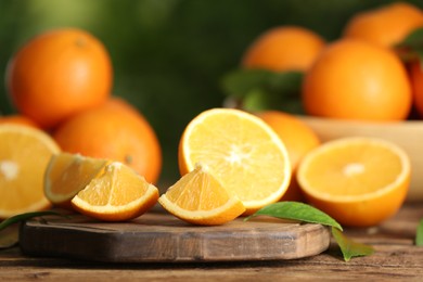 Photo of Fresh ripe oranges on wooden table against blurred background. Space for text