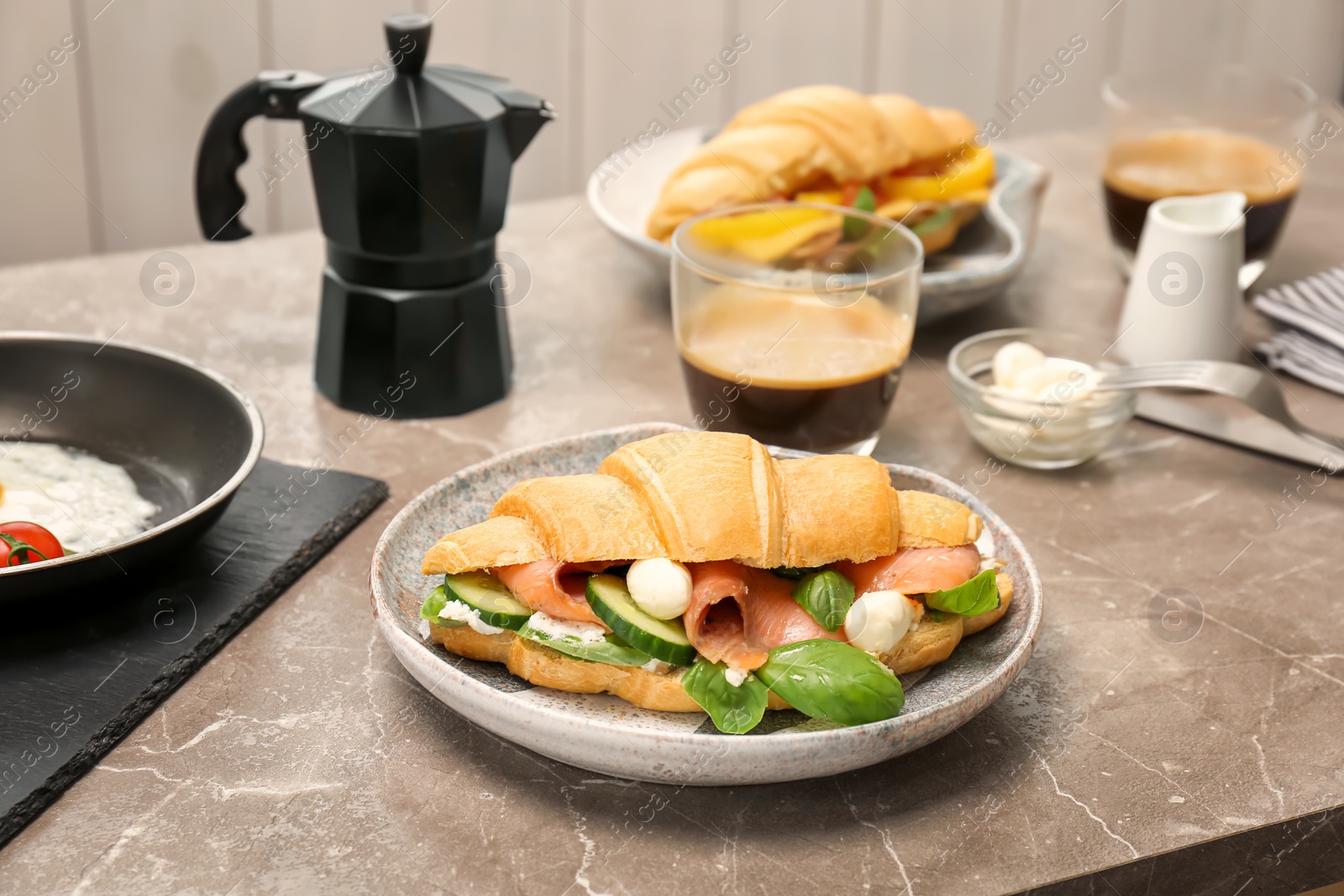 Photo of Plate with tasty croissant sandwich on table