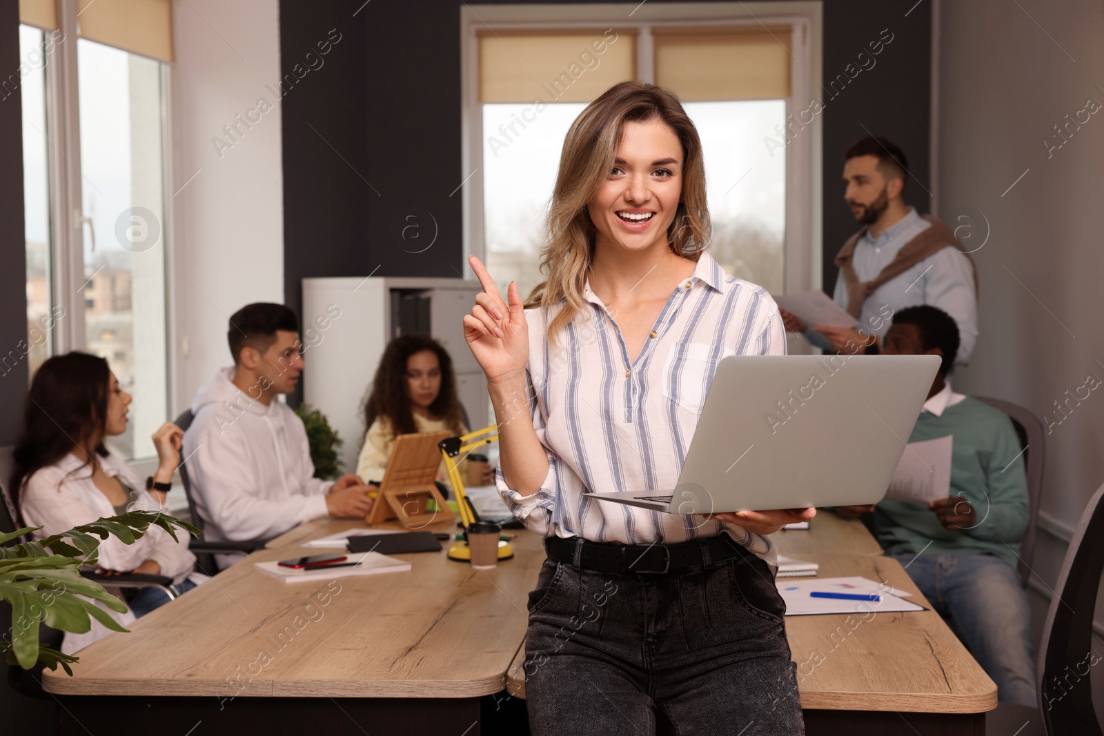 Photo of Portrait of happy young woman with laptop in office, space for text. Startup project