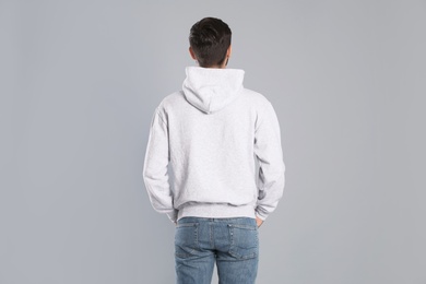 Photo of Young man in sweater on grey background. Mock up for design