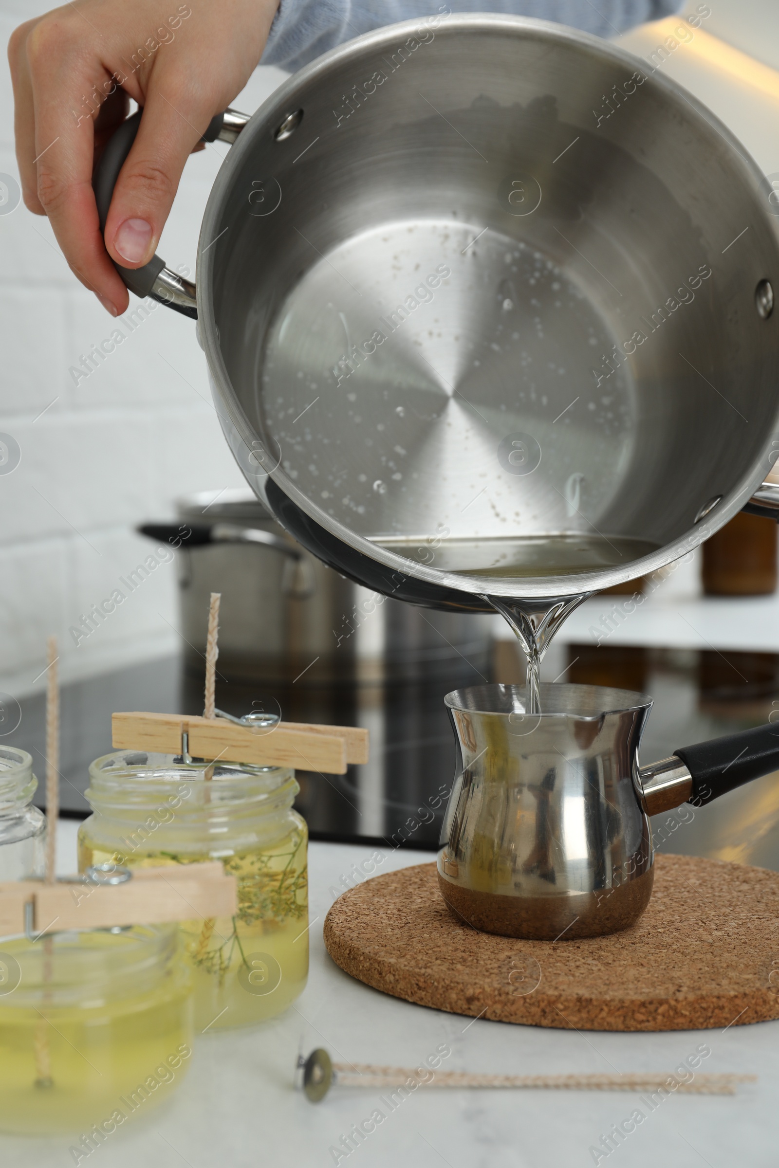 Photo of Woman making candles at white table, closeup