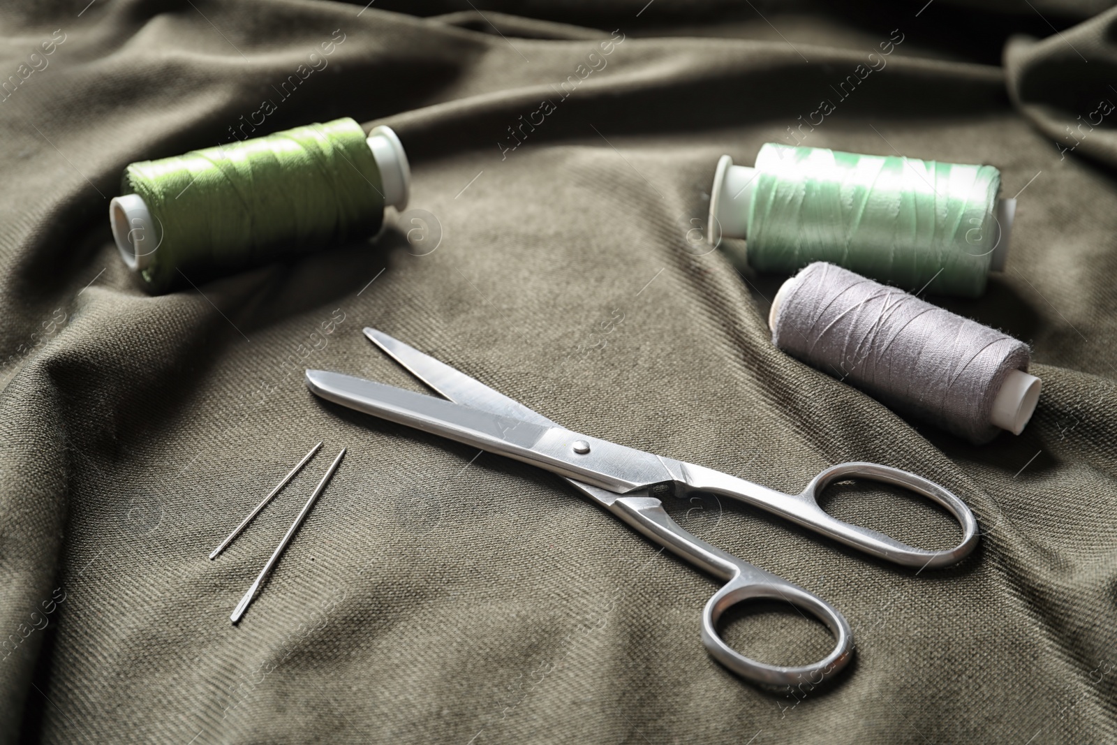 Photo of Scissors and threads on fabric. Tailoring equipment