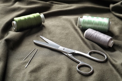 Scissors and threads on fabric. Tailoring equipment