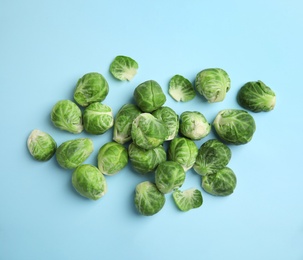Photo of Fresh Brussels sprouts on light blue background, flat lay