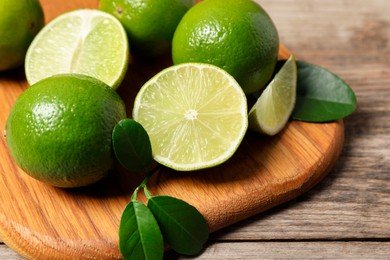 Photo of Fresh ripe limes on wooden table, closeup