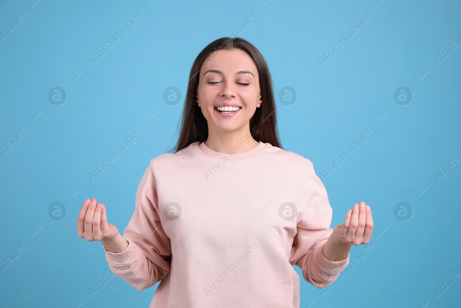 Photo of Young woman meditating on light blue background. Stress relief exercise